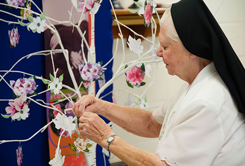 On September 21, 2019, sisters gathered for a celebration of gratitude and farewell to 145 years of SSND presences at Chatawa, Mississippi. Sister Gemma Marie places a printed flower on the remembrance tree, sharing her fondest moments at St. Mary of the 